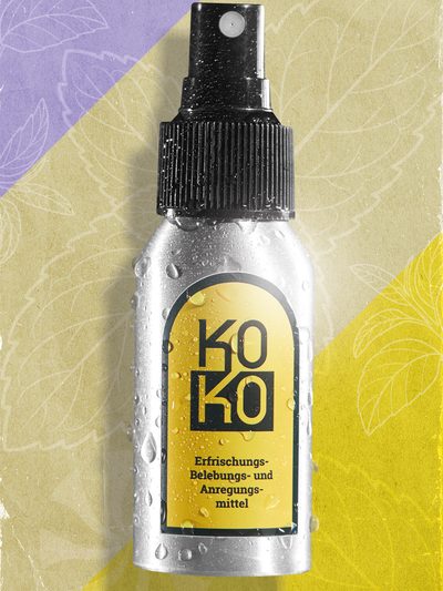 Die neue KoKo-Sprühflasche liegt auf einem Vintage-Papierhintergrund in Flieder, Beige und Gelb